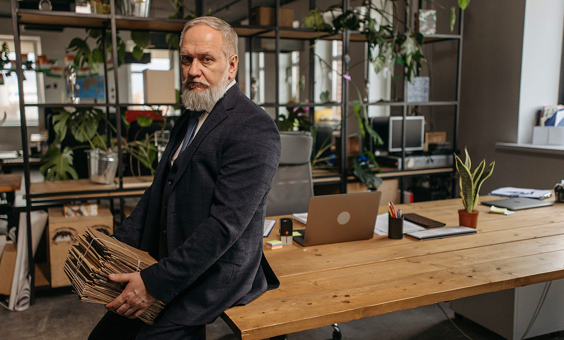 Homme assis sur une table portant des dossiers