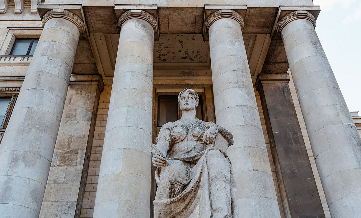 Statue devant bâtiment à colonnades
