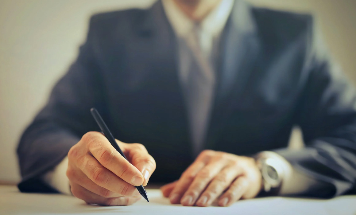 Homme écrivant sur une feuille de papier