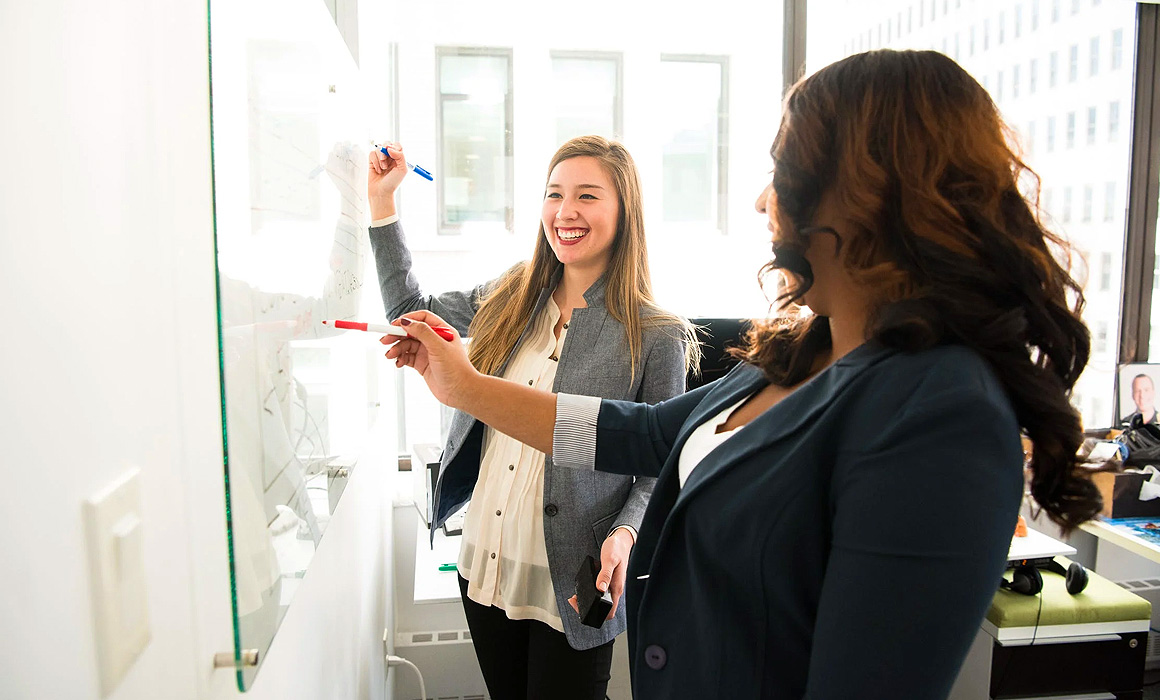 Femmes écrivant sur un tableau blanc