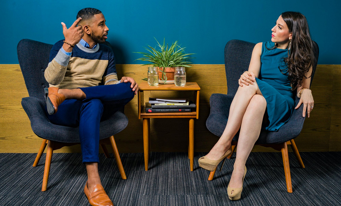 Homme et femme discutant assis sur des fauteuils