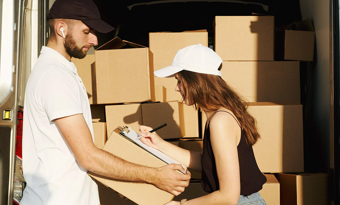 Jeune femme signant un colis à la réception