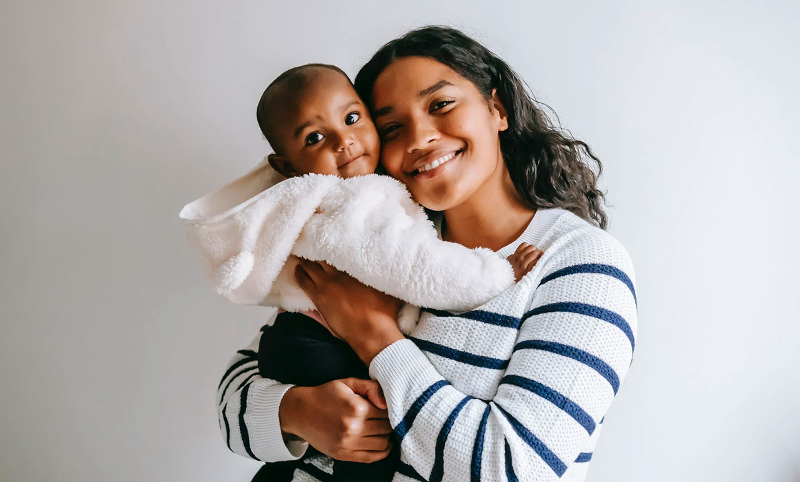 Femme portant un nourrisson dans ses bras