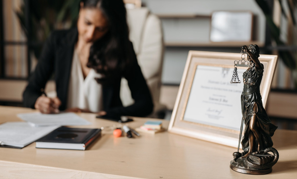 Femme assise à un bureau signant un document papier