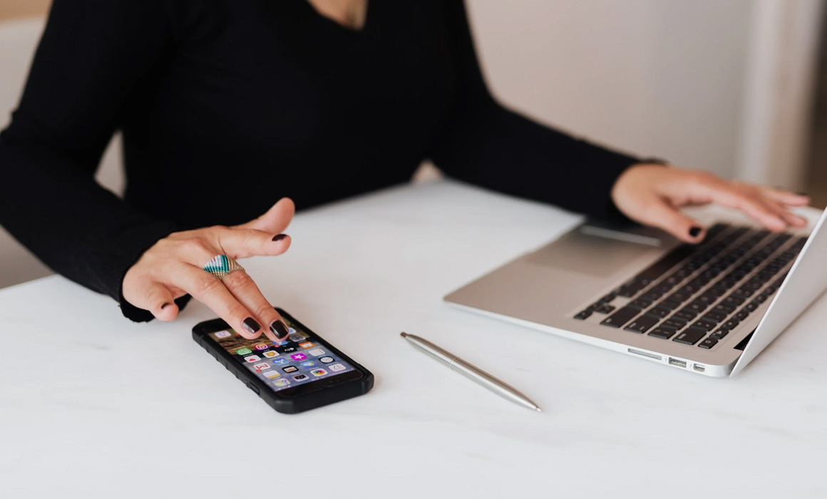 Personne travaillant sur un ordinateur et un smartphone