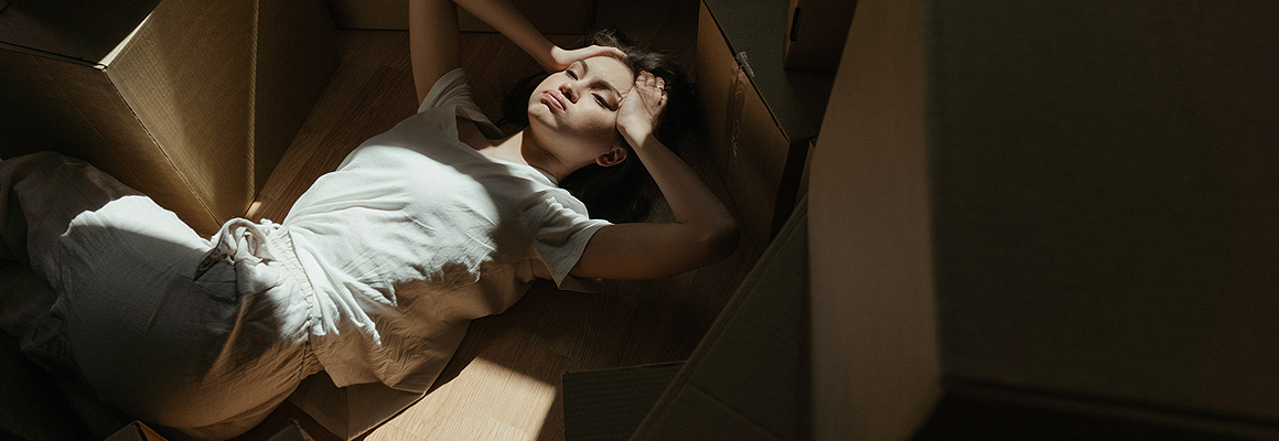 Femme allongée parmi des cartons